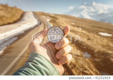 Compass in Hand mountain road background .Vintage Tone 41252919