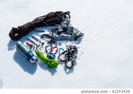 Close-up of winter climbing equipment on fresh snow on a sunny day. Carbines with a rope gazebo and Close-up of winter climbing equipment on fresh snow on a sunny day. Carbines with a rope gazebo and 41253439