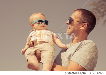 Father and baby son playing on the beach at the day time. Father and baby son playing on the beach at the day time. 41254268