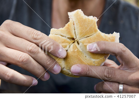 caucasian man eating a sandwich outdoors 41257007