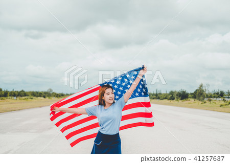 Happy woman standing with American flag Happy woman standing with American flag 41257687