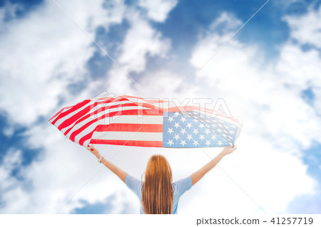 Happy woman standing with American flag Happy woman standing with American flag 41257719
