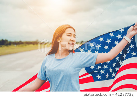 Happy woman standing with American flag Happy woman standing with American flag 41257722