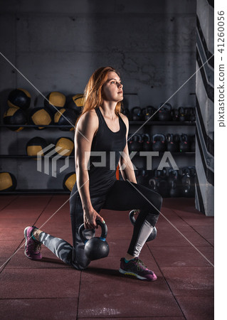 Attractive young female doing exercises with kettlebell. Attractive young female doing exercises with kettlebell. 41260056