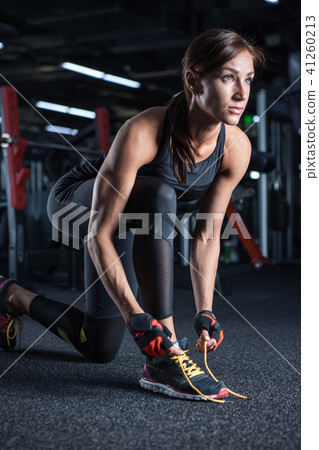 Young woman tying her shoelaces before exercise Young woman tying her shoelaces before exercise 41260213