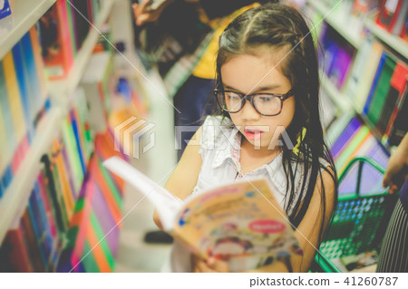 Asian child  holding open textbook in hands 41260787