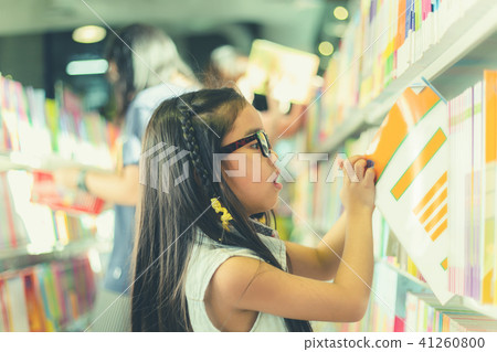 Asian child picking books from the bookshelf Asian child picking books from the bookshelf 41260800