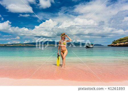 Beautiful young woman holding snorkeling equipment at Pink Beach 41261893
