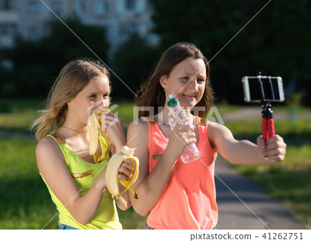 Young girls schoolgirl. Summer in nature. In hands holding a bottle of water. Baby bloggers and Young girls schoolgirl. Summer in nature. In hands holding a bottle of water. Baby bloggers and 41262751