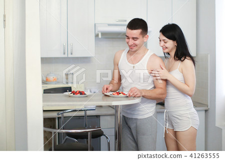 Husband and wife cooking breakfat in morning on kitchen, wearing shirts. Husband and wife cooking breakfat in morning on kitchen, wearing shirts. 41263555