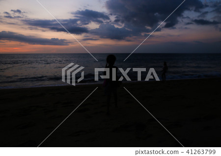 Little girl black silhouette on sea shore with mother walking in sunset in evening. Little girl black silhouette on sea shore with mother walking in sunset in evening. 41263799