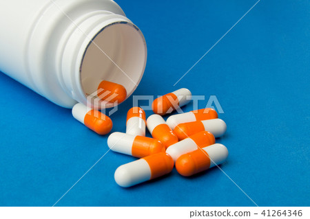 Orange white capsules (pills)  41264346