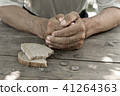 Hands the poor old man's piece of bread and change 41264363