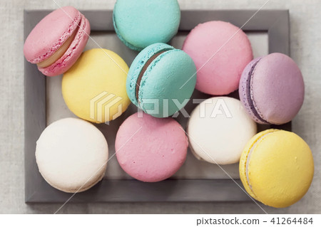 Fresh natural colorful macarons of different tastes in wooden frame, unusual abstract sweet art Fresh natural colorful macarons of different tastes in wooden frame, unusual abstract sweet art 41264484