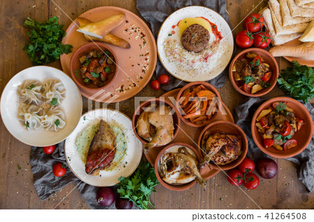 A lot of food on the wooden table. Georgian cuisine. Top view. Flat lay . Khinkali and Georgian A lot of food on the wooden table. Georgian cuisine. Top view. Flat lay . Khinkali and Georgian 41264508