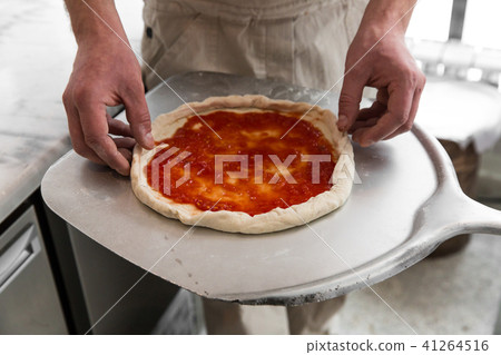 Fresh original Italian raw pizza, preparation in traditional style. Hands of chef baker making pizza Fresh original Italian raw pizza, preparation in traditional style. Hands of chef baker making pizza 41264516