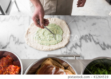 Fresh original Italian raw pizza, preparation in traditional style. Hands of chef baker making pizza Fresh original Italian raw pizza, preparation in traditional style. Hands of chef baker making pizza 41264519