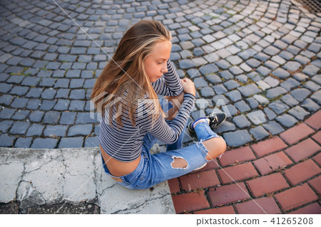 young teenage poses to photographer. blonde girl in jeans and blouse young teenage poses to photographer. blonde girl in jeans and blouse 41265208