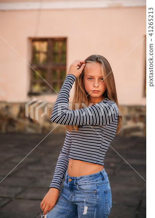 young teenage poses to photographer. blonde girl in jeans and blouse 41265213