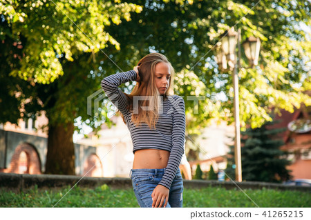 blonde teenage girl in striped blouse on the backgrountd of green tree blonde teenage girl in striped blouse on the backgrountd of green tree 41265215