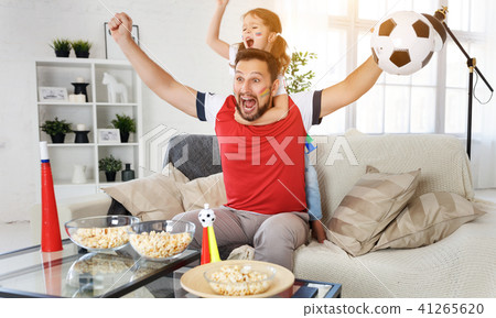 family of fans watching a football match on TV at home 41265620