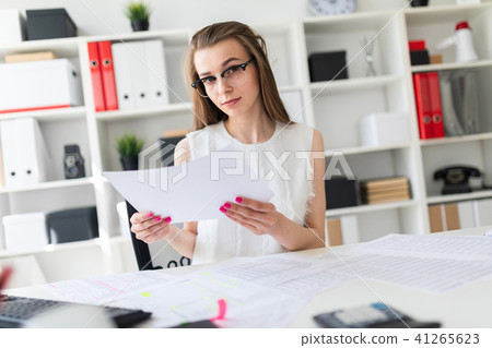 A young girl in the office is holding a sheet. A young girl in the office is holding a sheet. 41265623