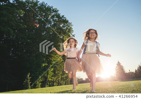 Two joyfull girls running against the sunset. 41266954