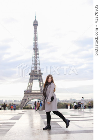 Caucasian woman in grey coat standing near Eiffel Tower in Paris. Caucasian woman in grey coat standing near Eiffel Tower in Paris. 41270935