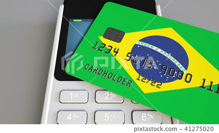 Payment or POS terminal with credit card featuring flag of Brazil. Brazilian retail commerce or 41275020
