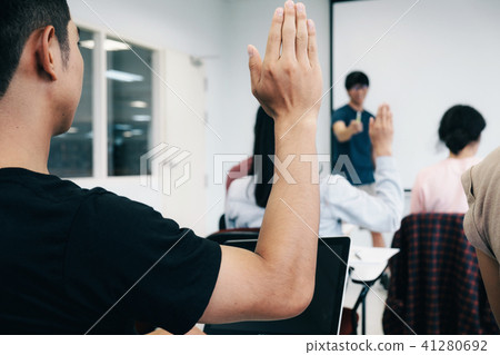Students raising hands in college lecture room. 41280692