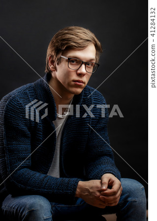 close up portrait of good-looking fair-haired student sitting on the chair close up portrait of good-looking fair-haired student sitting on the chair 41284132