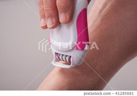 woman using electric epilator on legs woman using electric epilator on legs 41285081