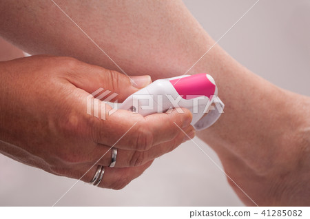 woman using electric epilator on legs woman using electric epilator on legs 41285082