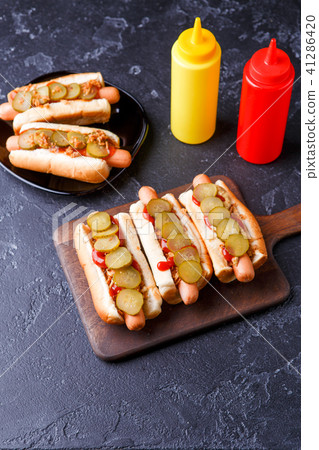 Photo on top of hotdogs on plate and board with ketchup and mustard 41286420