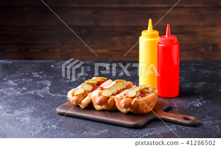 Image of hotdogs on cutting board at table 41286502