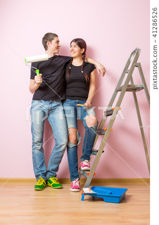 Photo of young woman and man with paint roller standing near staircase Photo of young woman and man with paint roller standing near staircase 41286526