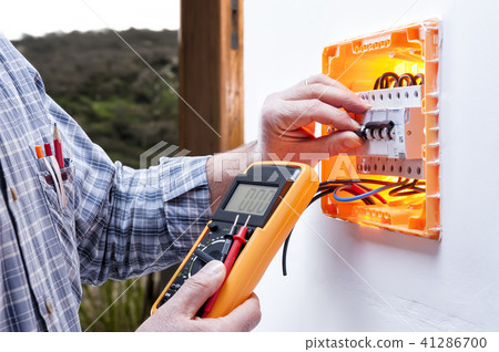 Electrician at work on an electrical panel 41286700
