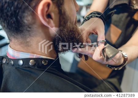 Close-up of the head of a young man and the hands of a hairstylist Close-up of the head of a young man and the hands of a hairstylist 41287389