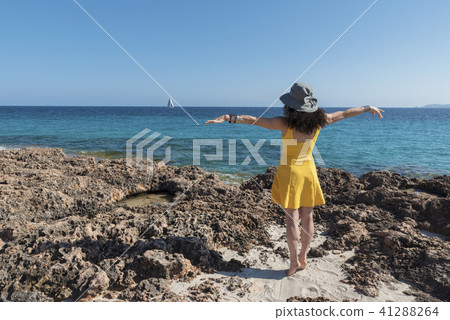 Yellow dressed woman on a beach. Selective focus Yellow dressed woman on a beach. Selective focus 41288264