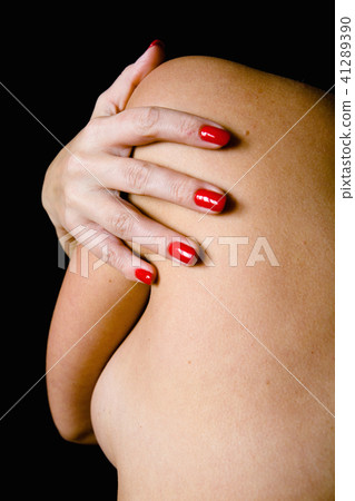 A beautiful woman's hand lies on her bare shoulder 41289390