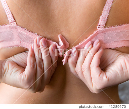 womens hands with a manicure unfasten the bra. womens hands with a manicure unfasten the bra. 41289670