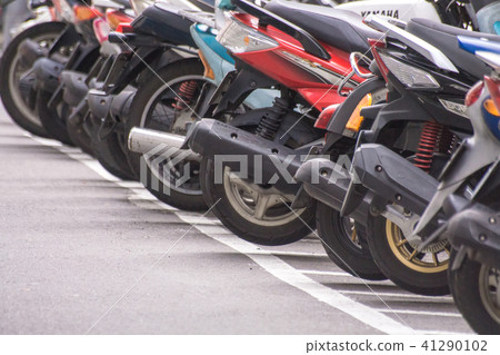 A row of motorcycle parking along the roadside A row of motorcycle parking along the roadside 41290102