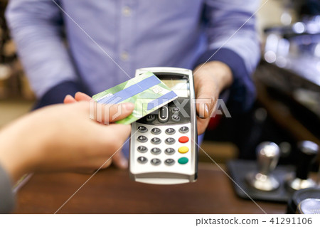 Photo of buyer man with bank card and seller with terminal in hand Photo of buyer man with bank card and seller with terminal in hand 41291106