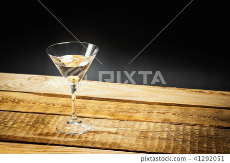 martini drink with olive in a glass on a wooden table martini drink with olive in a glass on a wooden table 41292051