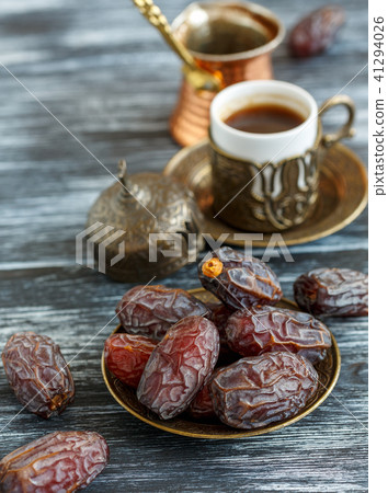 Dates on the plate, copper cezve and black coffee. 41294026