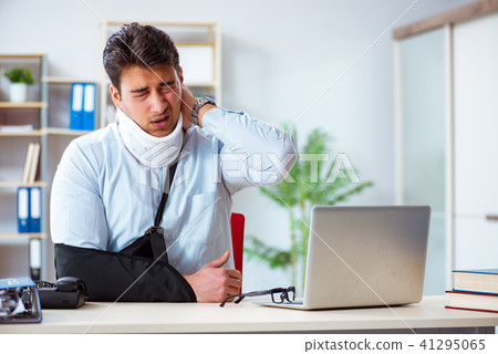 Businessman with broken arm working in office Businessman with broken arm working in office 41295065