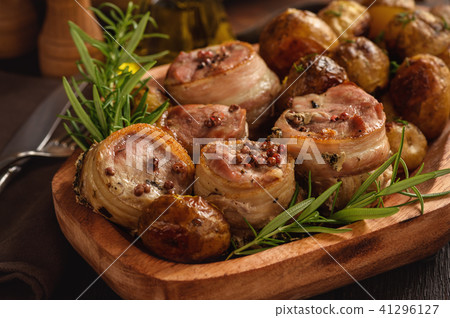 Baked pork medalions in bacon with potatoes. Baked pork medalions in bacon with potatoes. 41296127