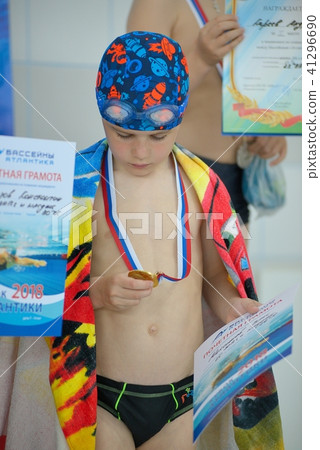 Sad little boy with a medal for swimming 41296690