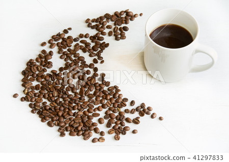 Mild roasted coffee beans with white cup at white Mild roasted coffee beans with white cup at white 41297833
