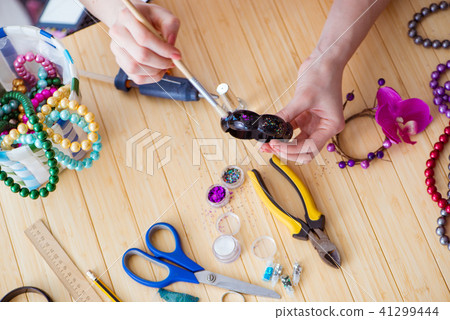 Woman making jewelry at home Woman making jewelry at home 41299444